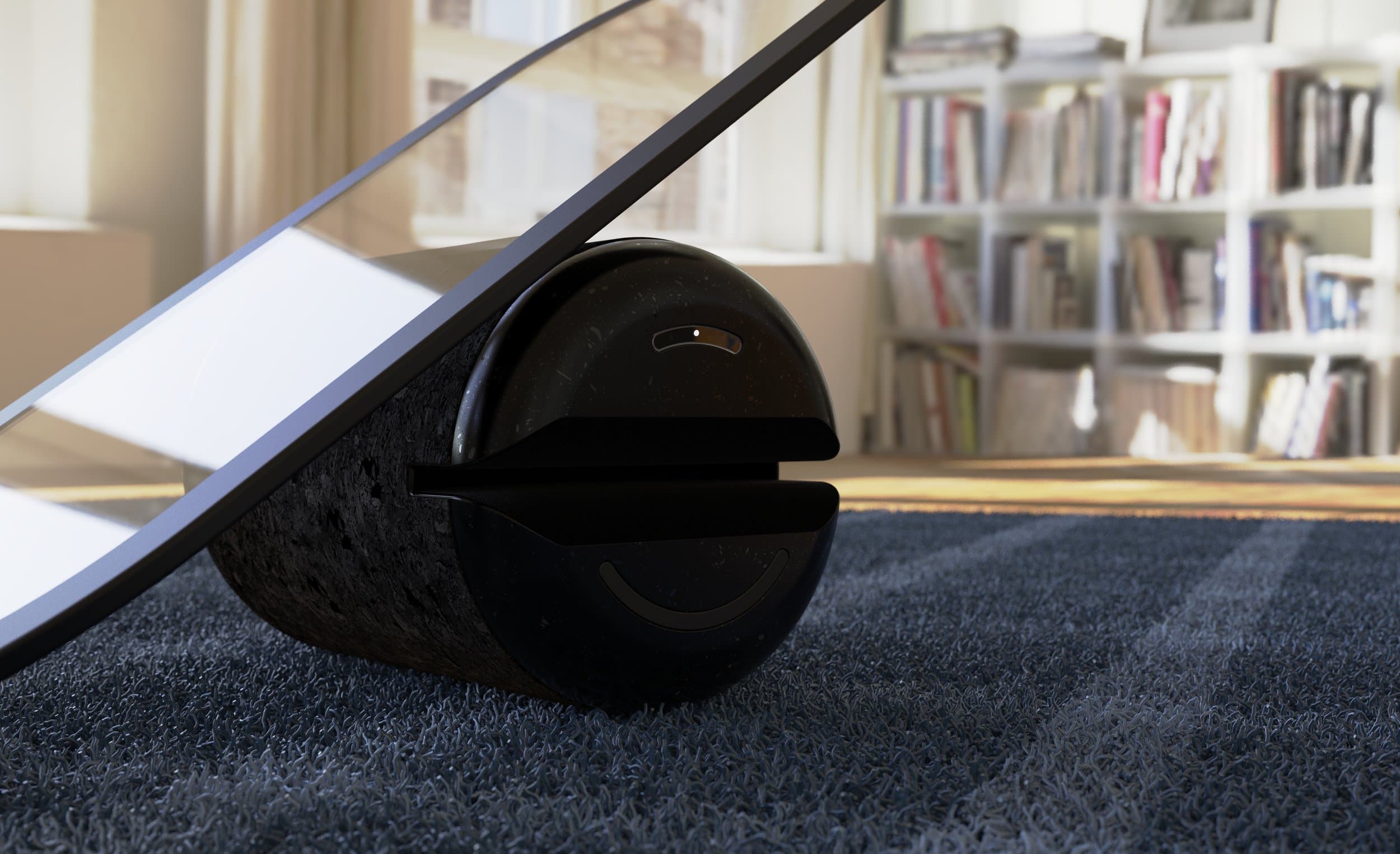Black balance board made of two parts - a black sleek cylinder on it's side with a glass panel resting on top