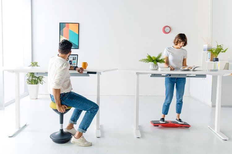 A woman and a man either standing or sitting on balance items